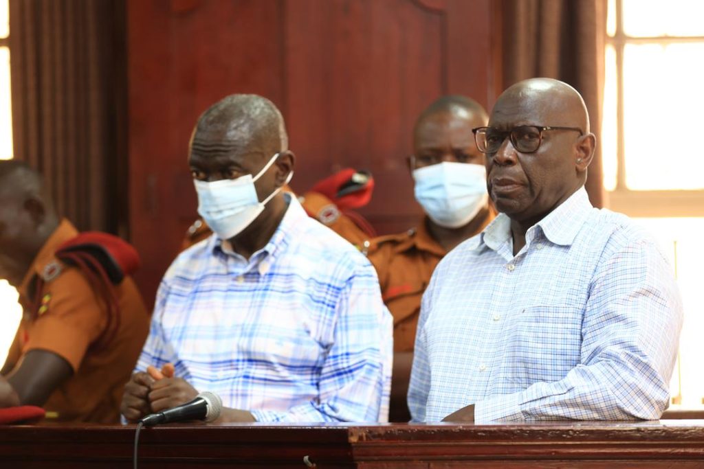 Veteran opposition politician Dr Kizza Besigye and his aide Hajj Obeid Lutale in the dock at the High court for the hearing of their bail application on March 14